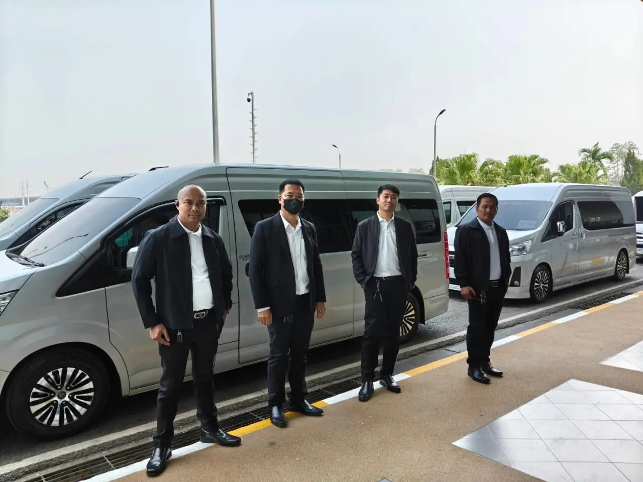คนขับยืนหน้ารถตู้ Toyota Commuter ของรถเช่าเชียงราย