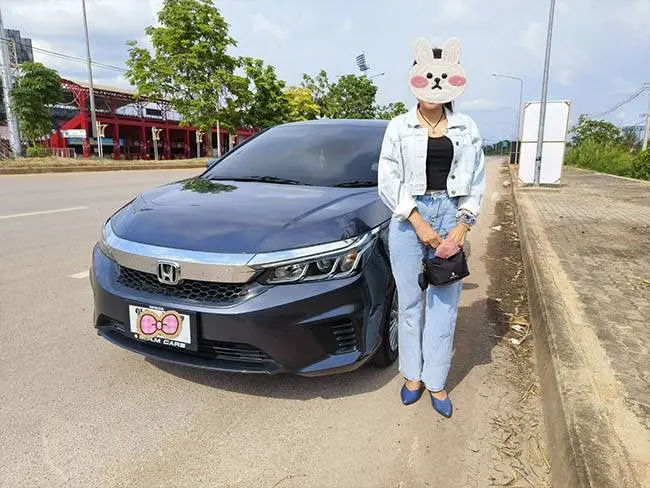 ลูกค้ายืนข้างรถเก๋ง Honda City สีเทาเข้มที่เช่าในเชียงราย