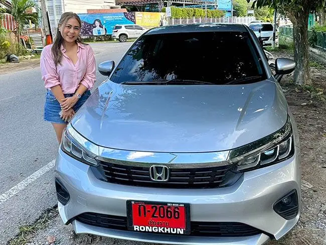 ลูกค้ายืนข้างรถเก๋ง Honda City สีเงินที่เช่าในเชียงราย