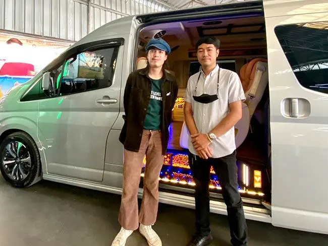ลูกค้าสองคนยืนหน้าประตูรถตู้ Toyota Commuter VIP